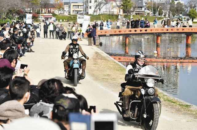 多くの観客が詰め掛ける中、ビンテージバイクを運転する愛好者たち＝津島市の天王川公園で 