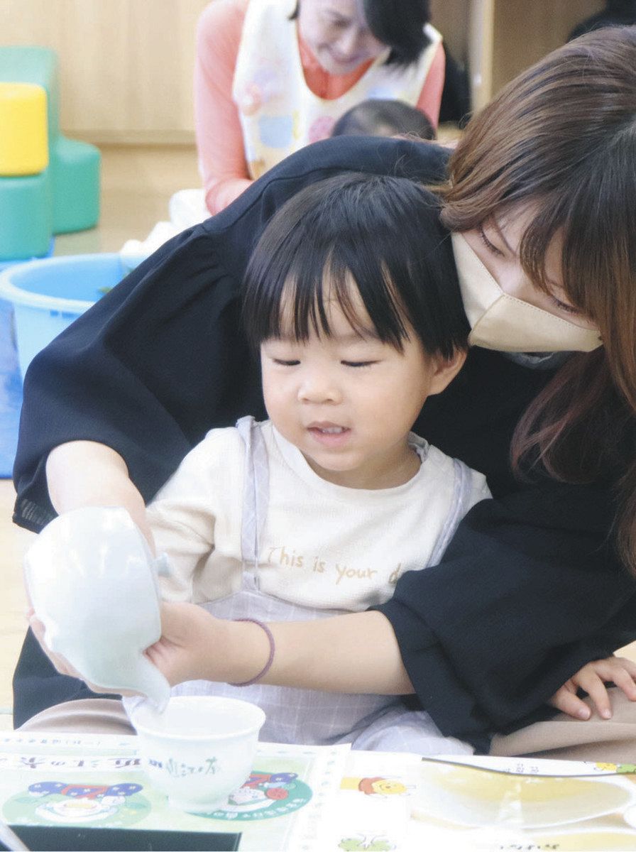 急須で土山産のかぶせ茶をいれる親子＝甲賀市土山町の土山子育て支援センターで