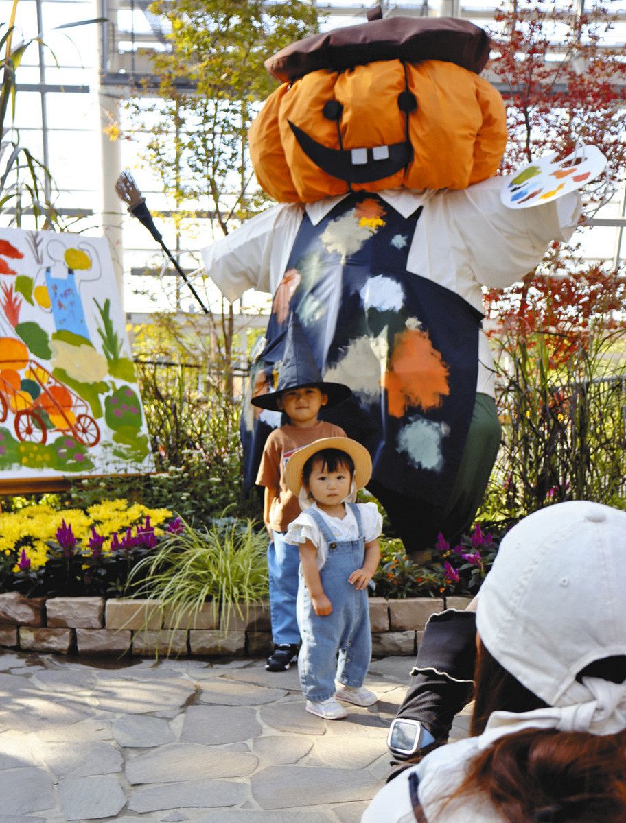 ハロウィーンの装飾の前で記念写真を撮る親子連れ＝安城市赤松町で