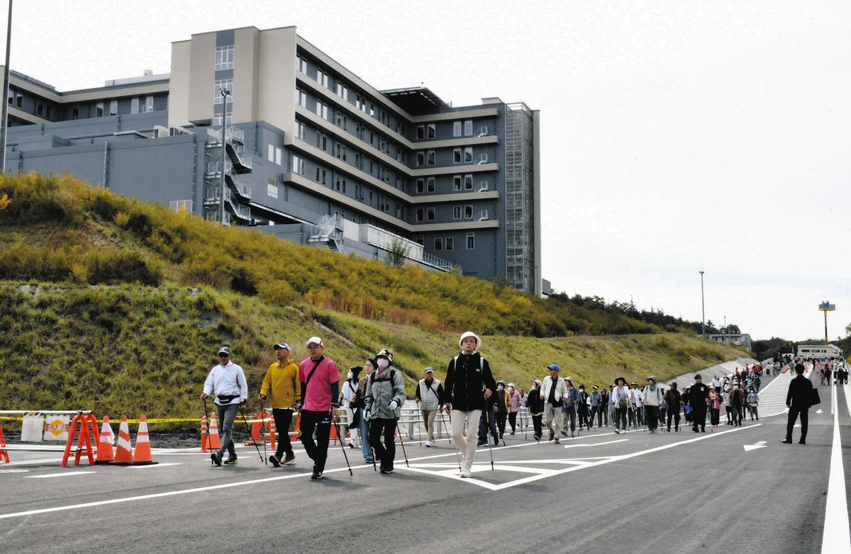 来年2月に開業する新病院へのアクセス道路となる市道陶元浅野線を歩く参加者＝土岐市肥田町浅野で
