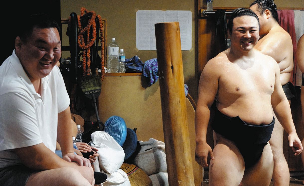 ２０２３年８月、幕下以下が着ける黒まわし姿で稽古を再開して笑顔の炎鵬（右）と宮城野親方。翌年名古屋場所、序ノ口で復帰した