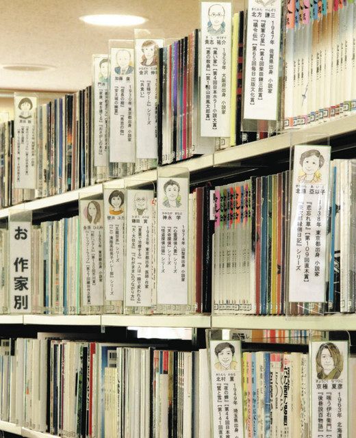 作家の似顔絵が描かれた見出しが並ぶ書棚＝松川村図書館で