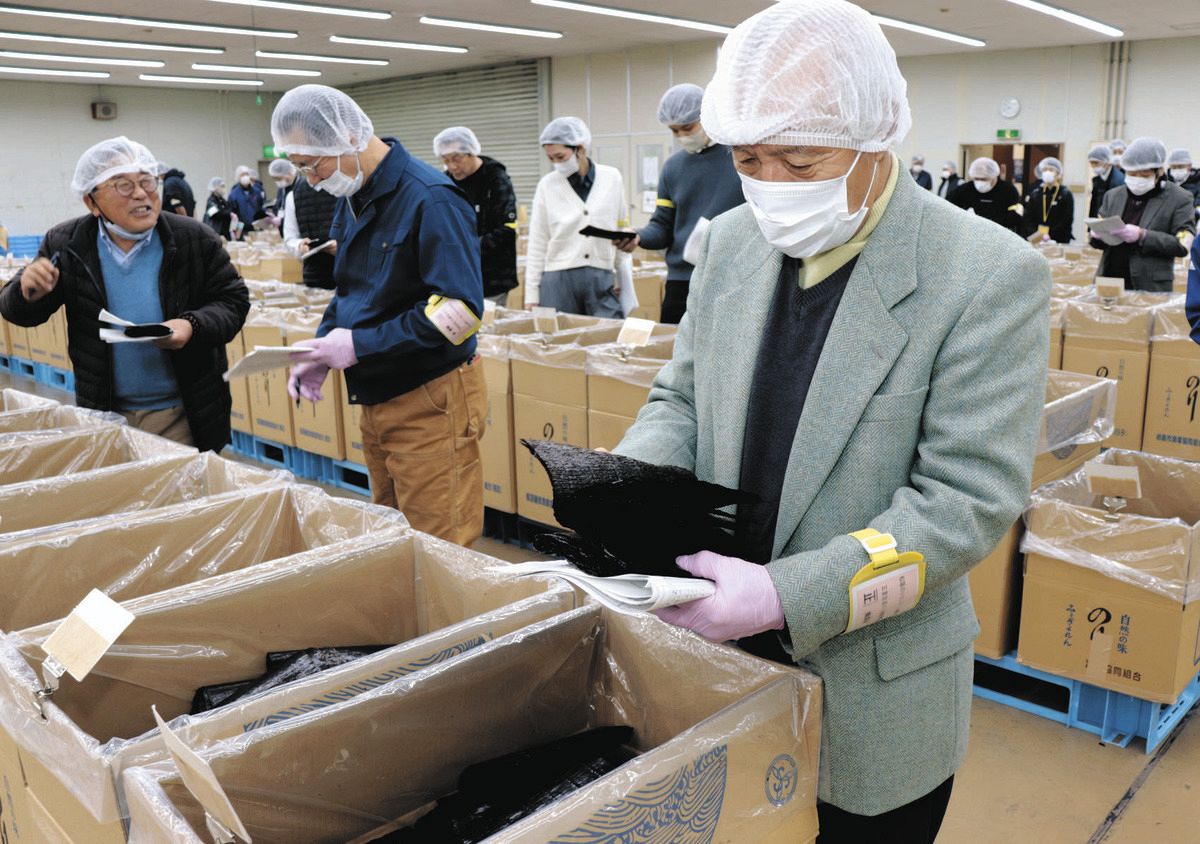 出品された黒のりの出来栄えを見る参加者ら＝松阪市中央町ののり流通センターで