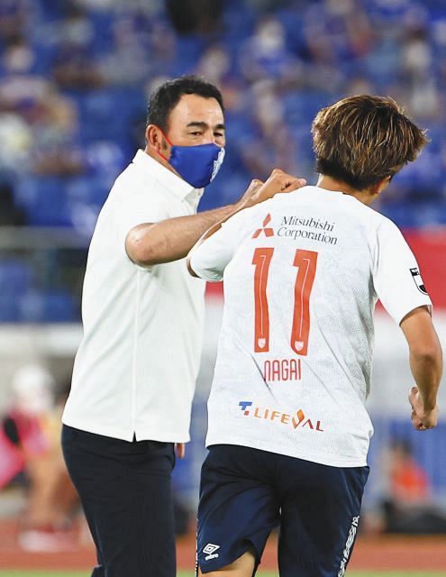 後半、レアンドロのゴールをアシストした永井（右）と肘タッチをかわすFC東京の長谷川監督
