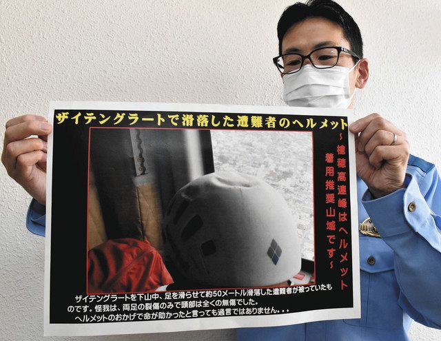 遭難者がかぶっていたヘルメットの写真から、ヘルメットの効果を訴えるポスター＝松本署で 