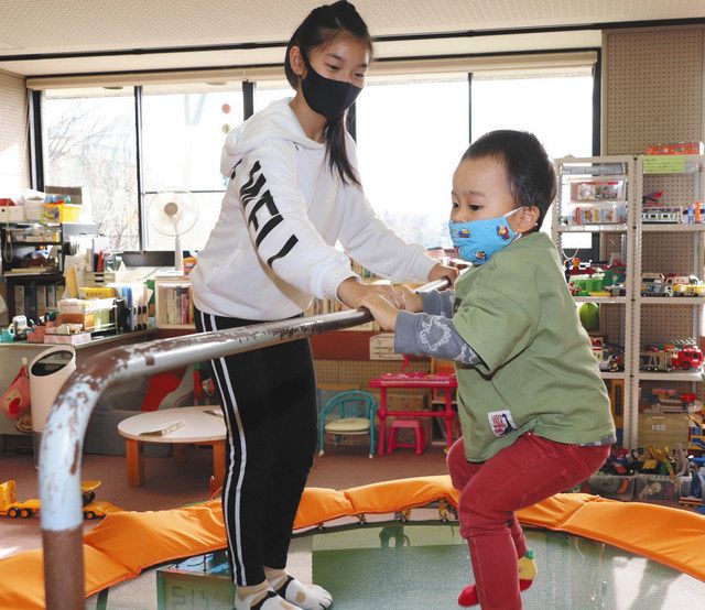 子どもとトランポリンで遊ぶ田中杏璃さん（左）＝小松市符津町で