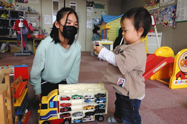 子どもに車の名前を教えながらミニカーで遊ぶ角田優乃音さん（左）＝小松市符津町で