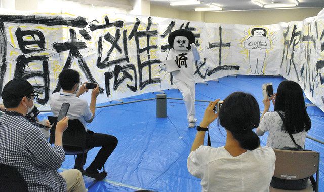 自らが制作した巨大壁画を前にファンとの交流を楽しむオカザえもん（中央）＝岡崎市美術館で 