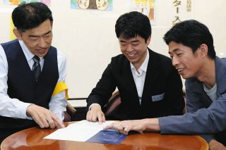 歴代の名簿を見ながら活動を懐かしむ（右から）西川さん、高田さん、加藤さん＝神戸町中央公民館で