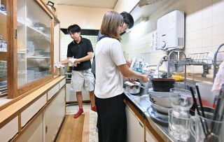 じゃんけんで負けた先生が台所で食器を片付ける