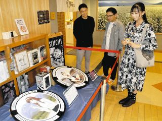 hanaさん（右）にマンホールを紹介する佐藤社長（左）と酒井社長＝中津川市坂下の道の駅きりら坂下で
