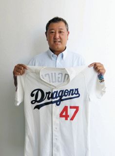 自宅で保管していた自らのユニホームを手にする野口茂樹さん