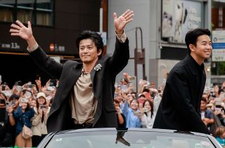 沿道の人たちの声援に応える俳優の小栗旬さん㊧と仲野太賀さん