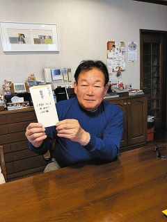 宝物である監督賞の封筒を手にする鈴木孝政さん