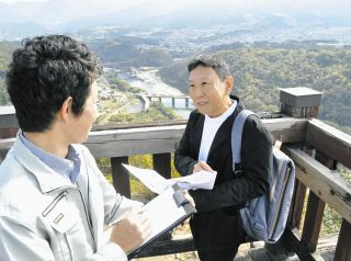 木曽川を望む苗木城天守跡で市職員とデータ収集の打ち合わせをする大橋教授（右）＝同市苗木で