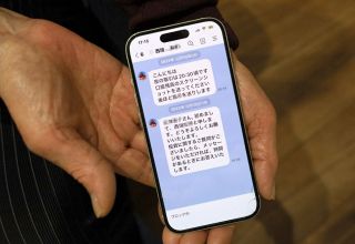 うその投資話を持ちかけられたLINEを表示する女性