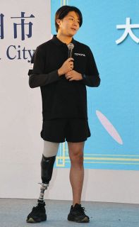 アジアパラ大会の注目選手を紹介する佐藤さん＝名鉄豊田市駅前で