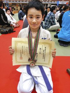 柔道の大会で賞状を手にする小学4年当時の鵜飼＝鵜飼拓人さん提供