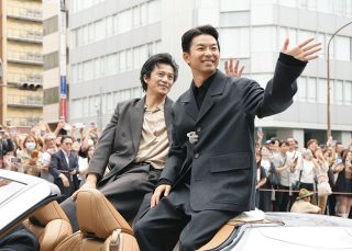 オープンカーに乗り込み、沿道の人たちに手を振る俳優の小栗旬さん（左）、仲野太賀さん