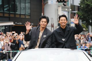 オープンカーに乗り込み、沿道の人たちに手を振る俳優の小栗旬さん（左）、仲野太賀さん