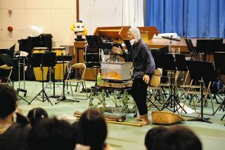 マジックで水槽のドジョウを金魚に変える浦西さん＝津市安濃町の村主小で
