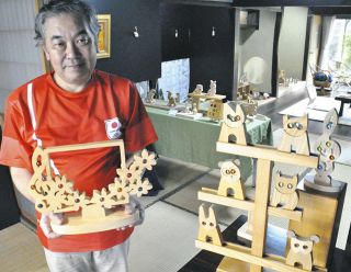 ビー玉をはめ込んだ温かみのある木工芸品を展示した牧野さん＝中津川市馬籠で