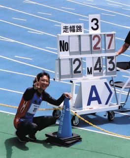 日本新記録を表示するボードを前に笑顔の岡田さん＝愛知県美浜町で（岡田嵩英さん提供）
