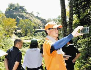スマートフォンをかざしてＶＲを体験する参加者ら＝中津川市の苗木城跡で