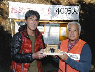 愛岐トンネル群の40万人目の来場者となり、愛岐トンネル群保存再生委員会の村上真善理事長（右）から記念品を贈呈された沢本さん