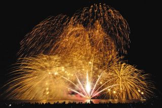 昨年7月の津花火大会で打ち上げた花火が滝のように舞い落ちる「黄金大瀑布」＝津市の阿漕浦海岸で（多重露光）
