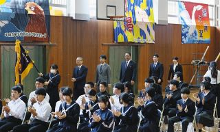 学校旗を先頭に離任式が行われる体育館を歩く教員ら
