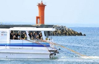 歓送式を終え、生徒たちに手を振る前篠島中教諭の水谷友紀さん（右端）ら。紙テープがなびき、汽笛とともに港を離れた